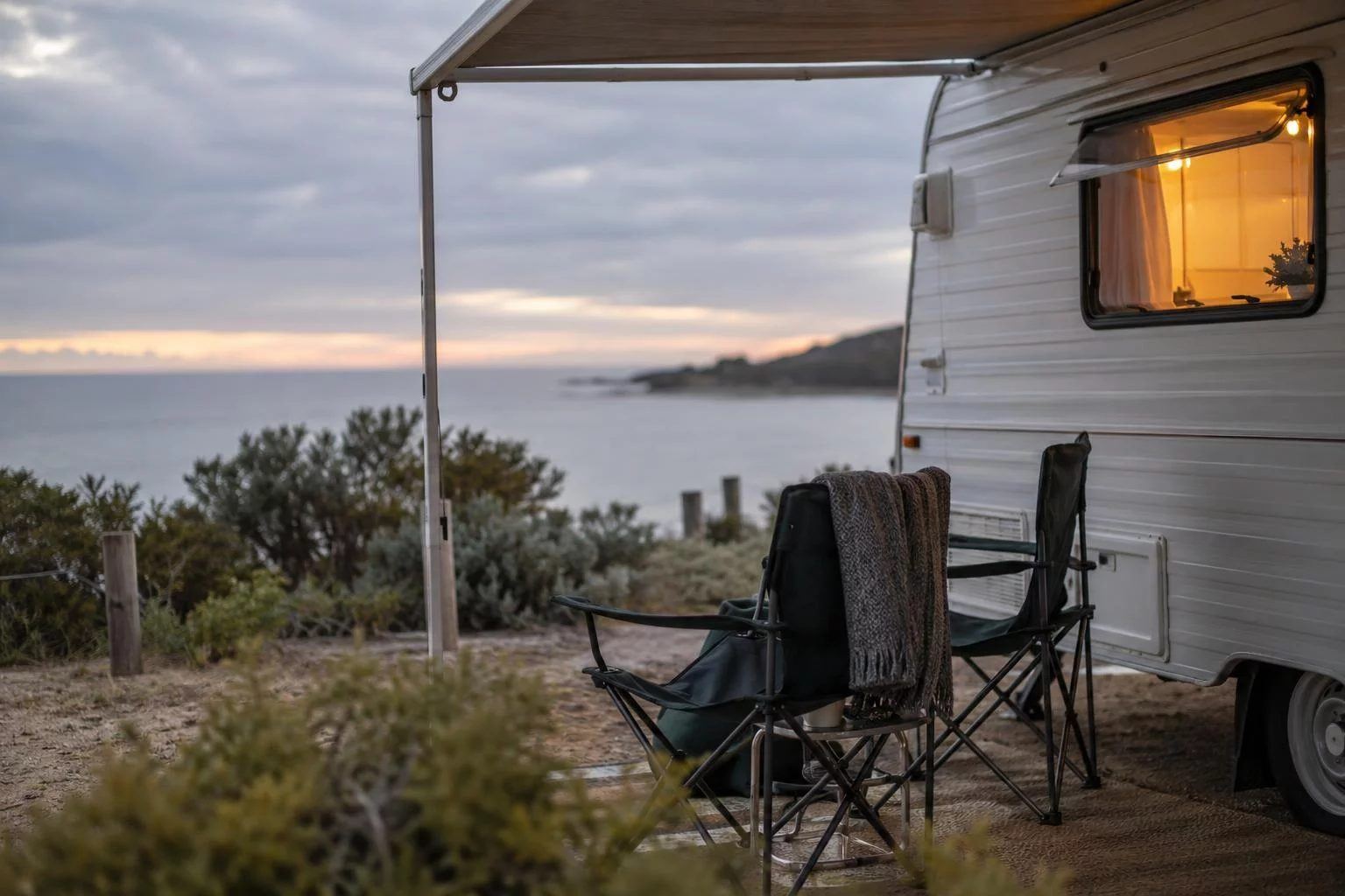 A caravan at a coastal campsite at dusk